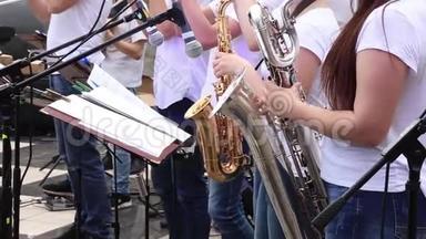 女音乐家在市管乐团演奏萨克斯风，在露天音乐会上演奏。